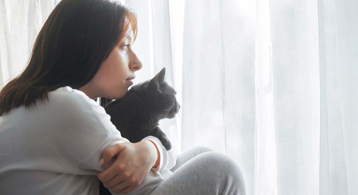 Una mujer abraza a su gato