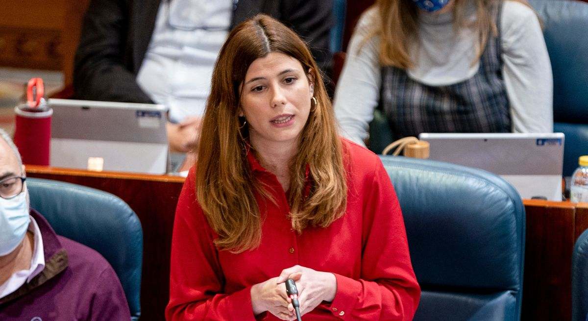 La diputada de más madrid con las manos juntas hablando y con una blusa roja