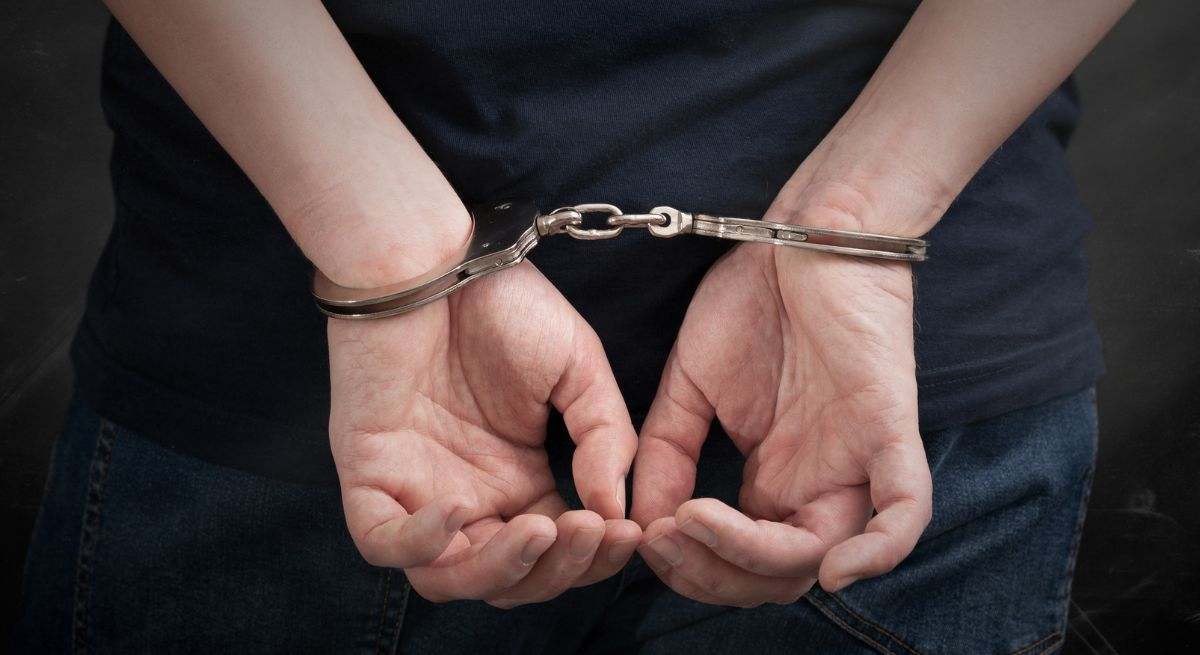 hombre-detenido-esposas-detalle-canva.jpg