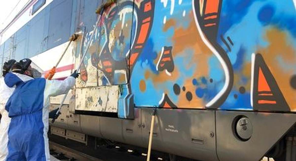Operarios de la limpieza borrando una de las pintadas realizadas como consecuencia de actos vandálicos.