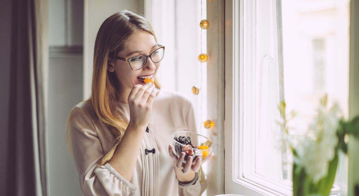 chica comiendo frutas deshidratadas