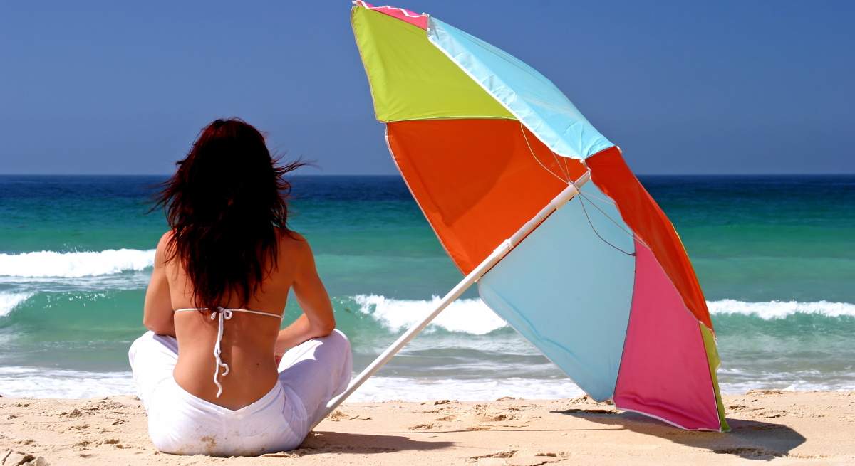 mujer-espaldas-playa-sombrilla-dreamstime.jpg