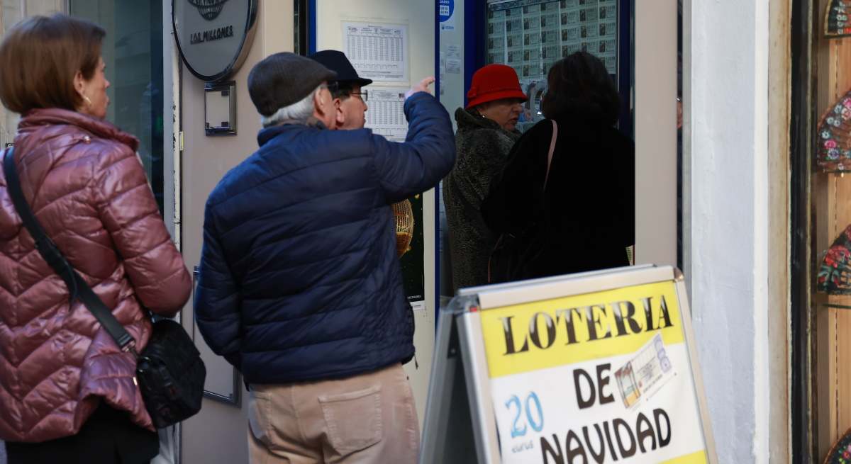 Varias personas hacen cola para comprar Lotería de Navidad.