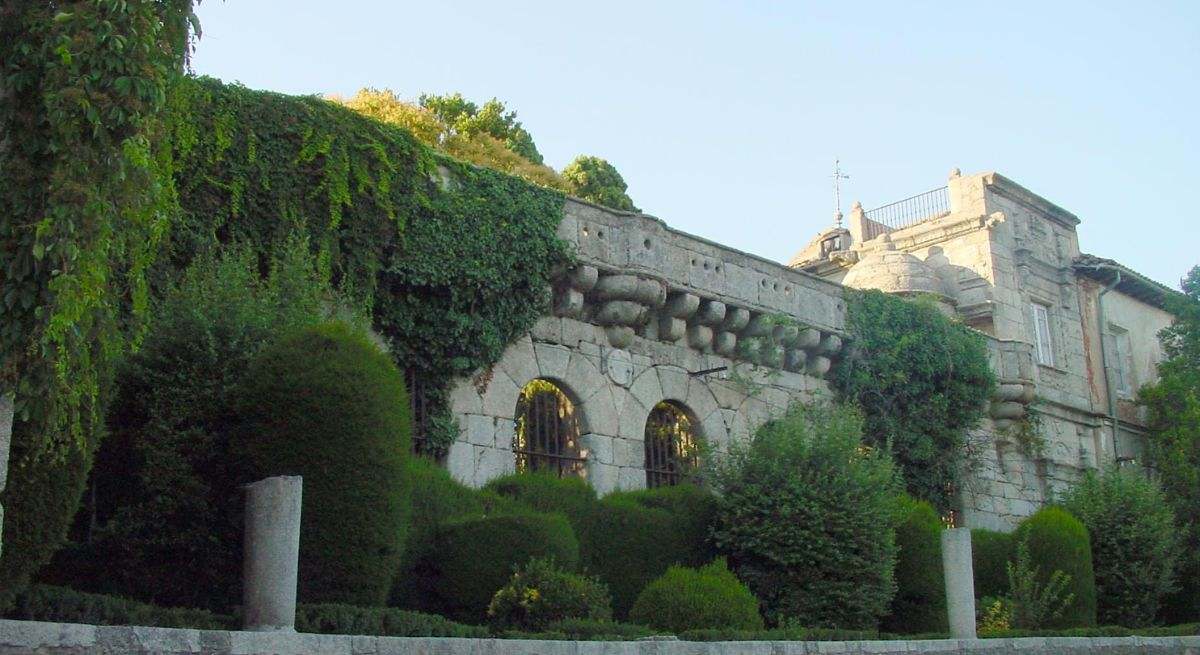 Palacio de Cadalso de los Vidrios rodeado de maleza y vegetación
