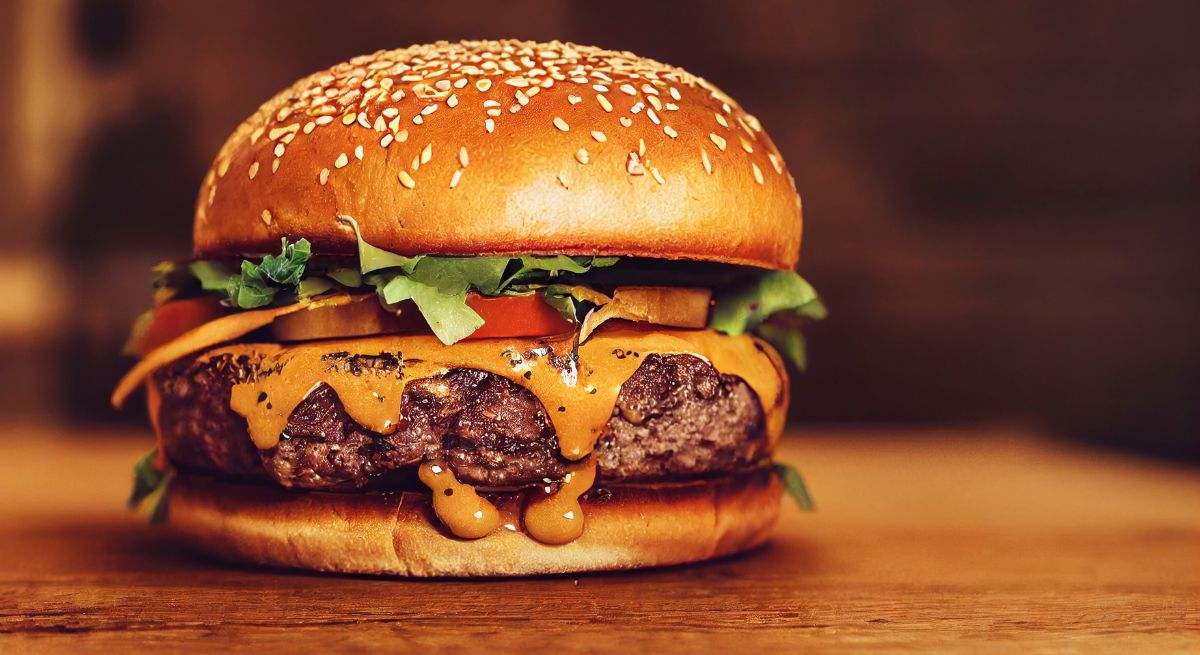 Una hamburguesa completa sobre una mesa de madera