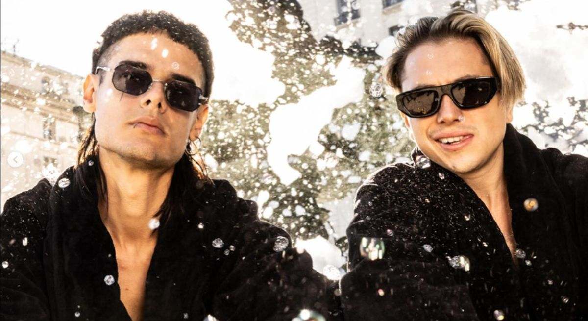 El duo de trup formado por dos argentinos en la nieve con gafas de sol y traje negro