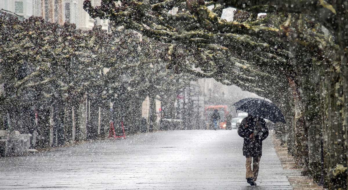 Una persona camina en Burgos bajo la nieve.