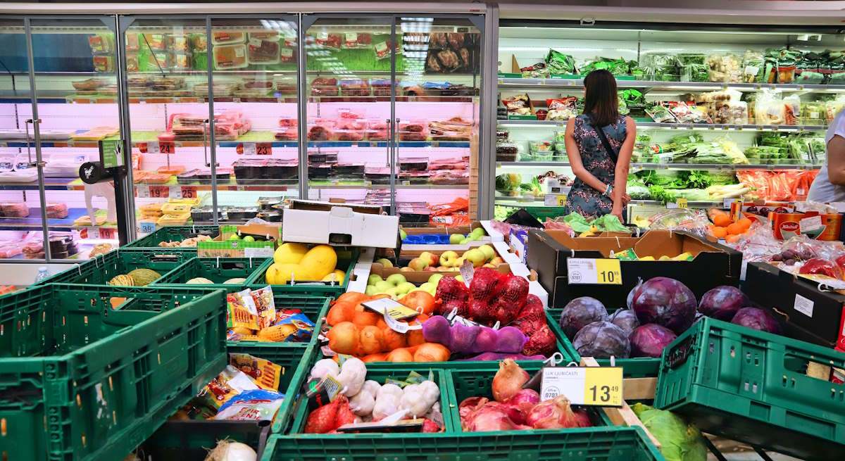 Persona en la sección de frutas y verduras de un supermercado. Foto: iStock