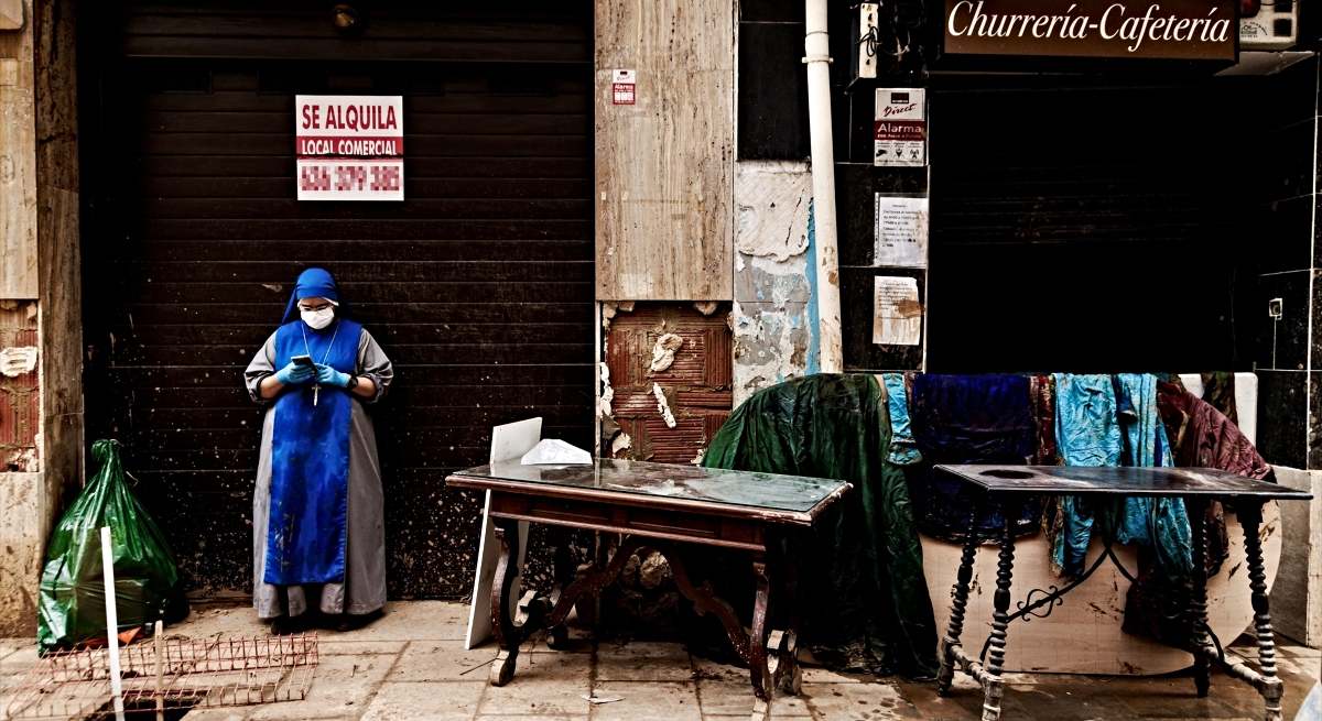 Una monja junto a varias sotanas tendidas para secarse tras la DANA / EP