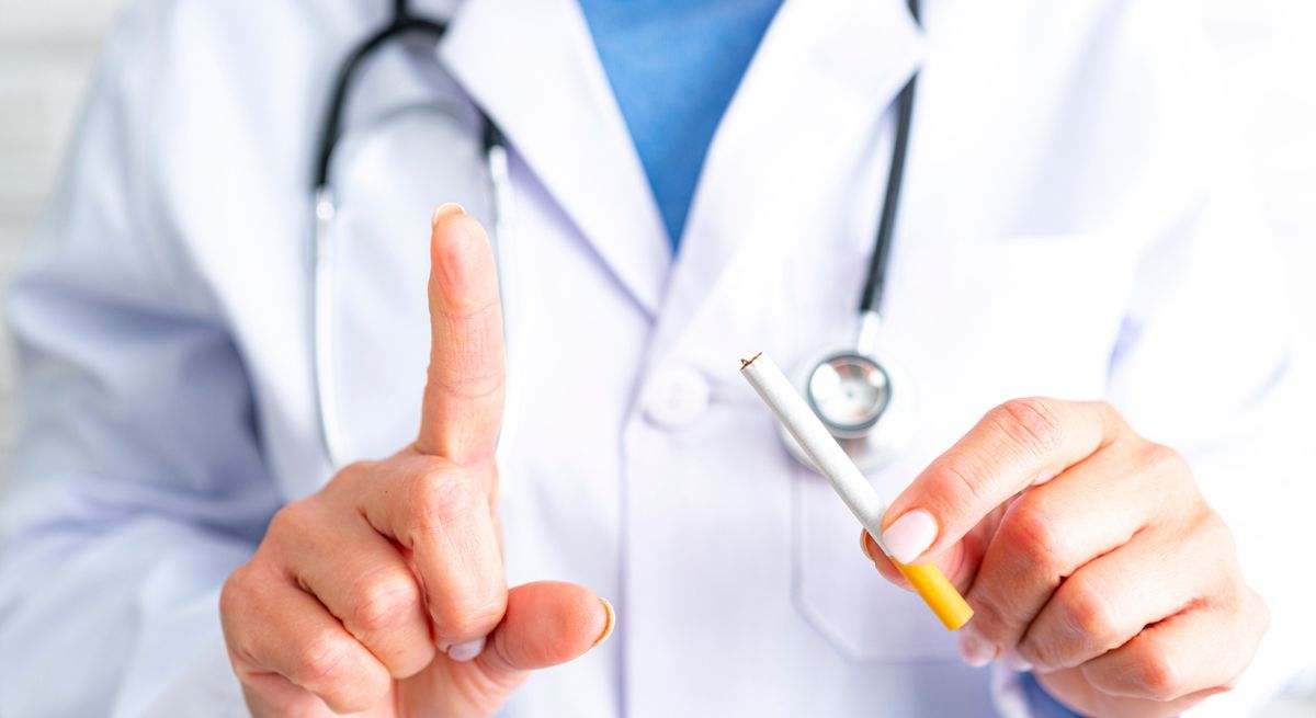 Cigarrillo en la mano de un doctor