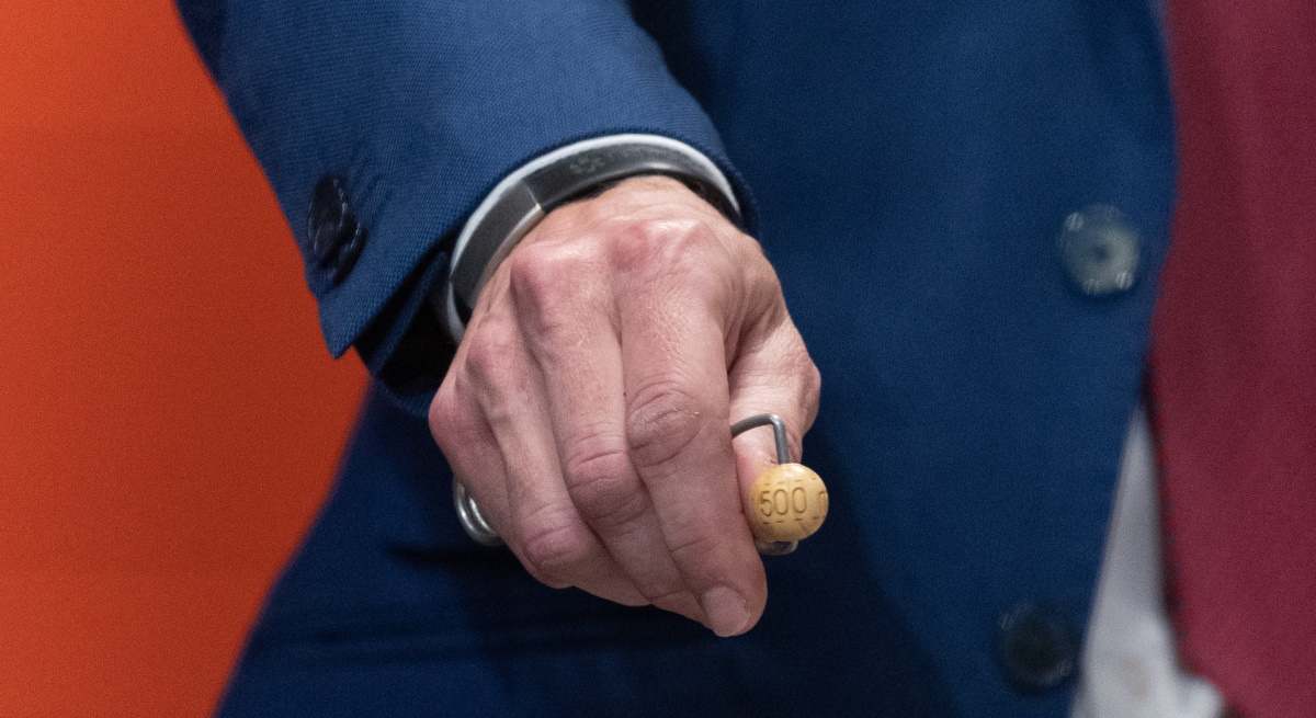 Un trabajador de Loterías muestra una bola del bombo de los premios del sorteo de Navidad.