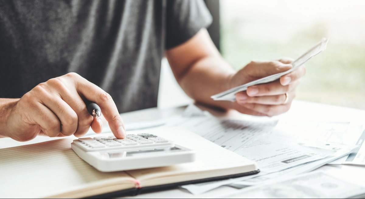 Una persona hace cuentas con una calculadora