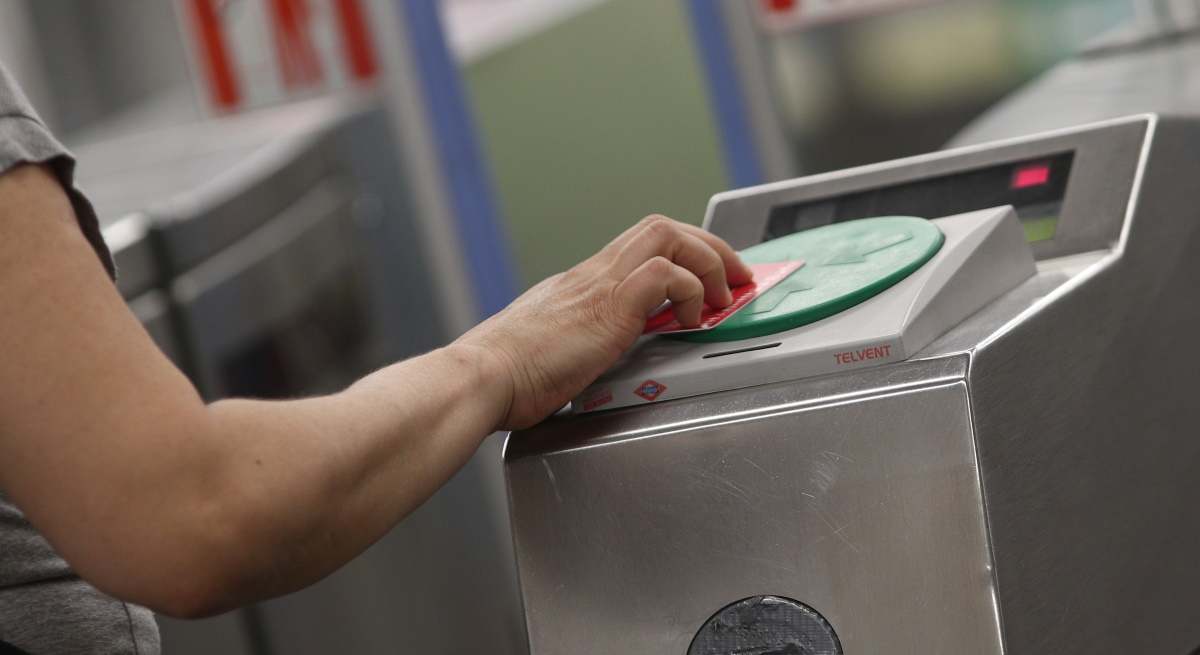 Una persona pasa su tarjeta abono para acceder al Metro de Madrid.