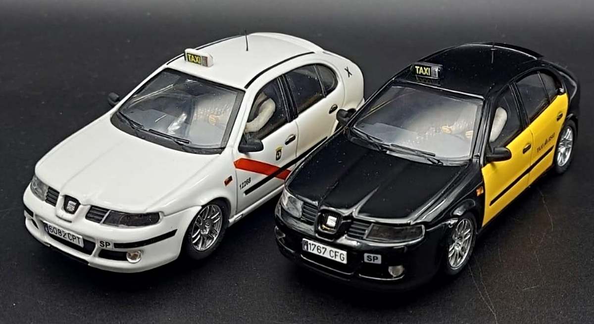 Dos coches de Scalextric: taxi de Madrid y de Barcelona