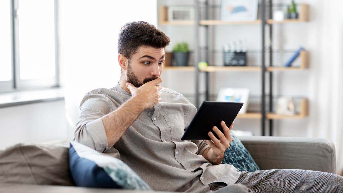 Un hombre sorprendido realiza una consulta en su tablet.