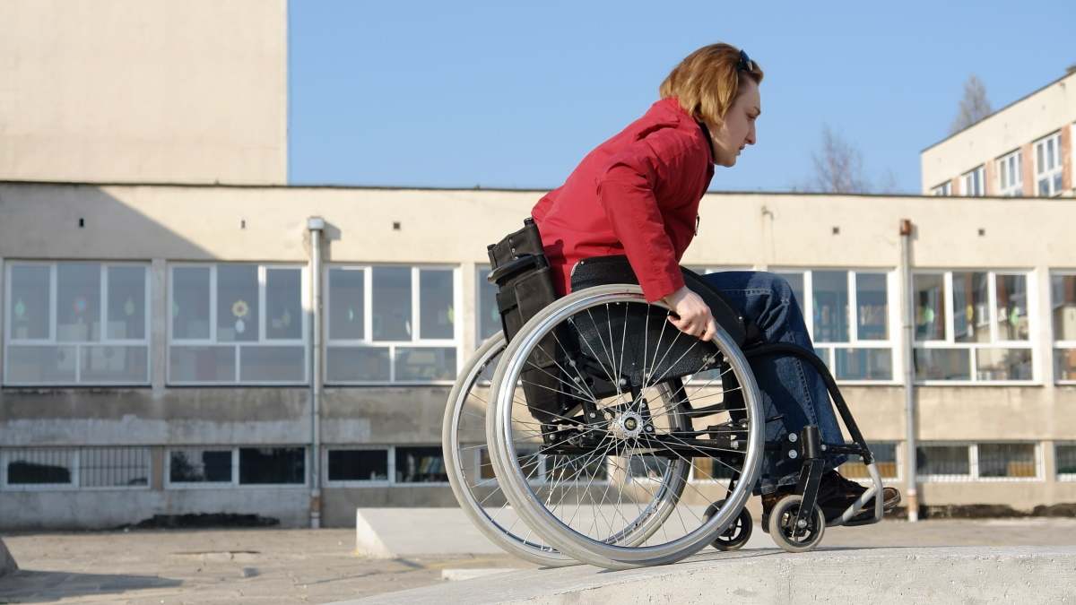 Una mujer sube una rampa en una silla de ruedas.