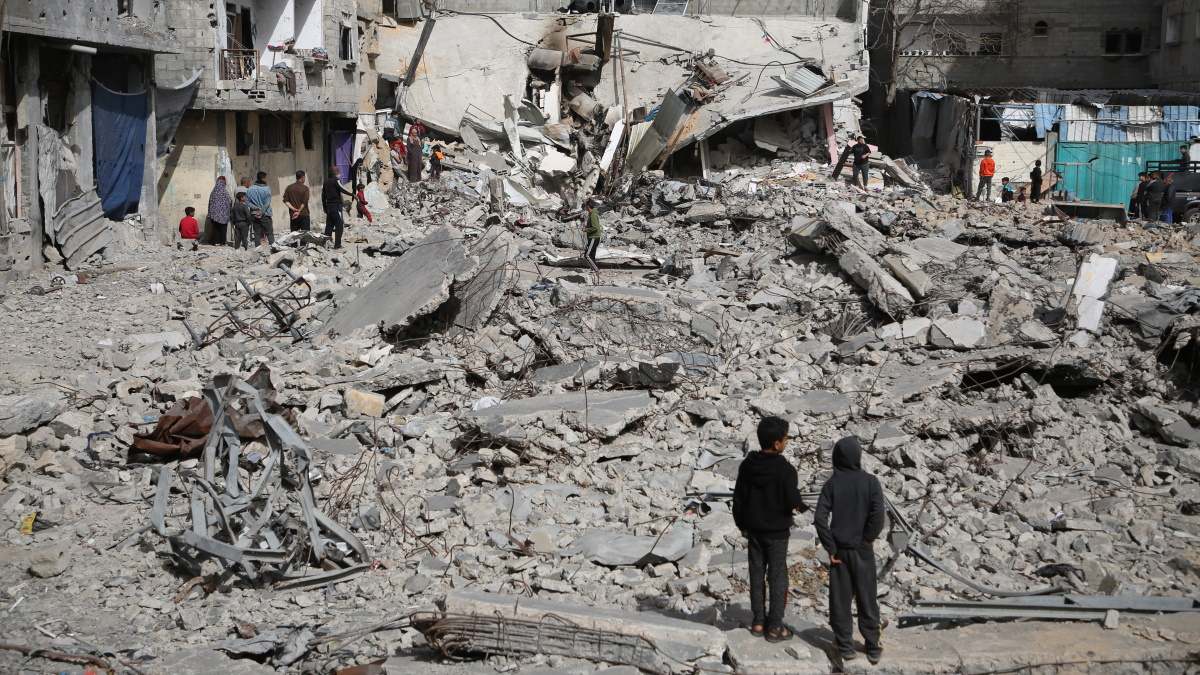 Niños gazatíes al lado de unos escombros causados por un bombardeo de Israel.