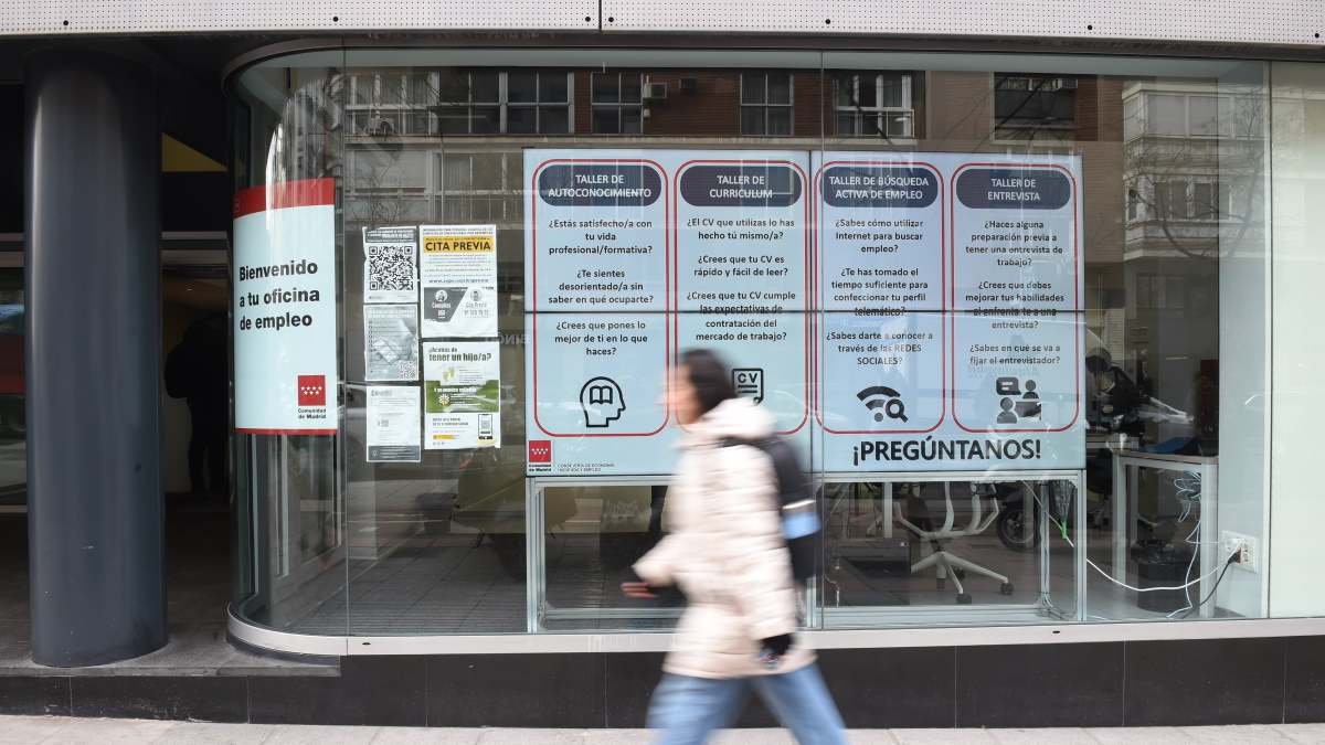 Mujer camina rápido frente a una ofician de empleo