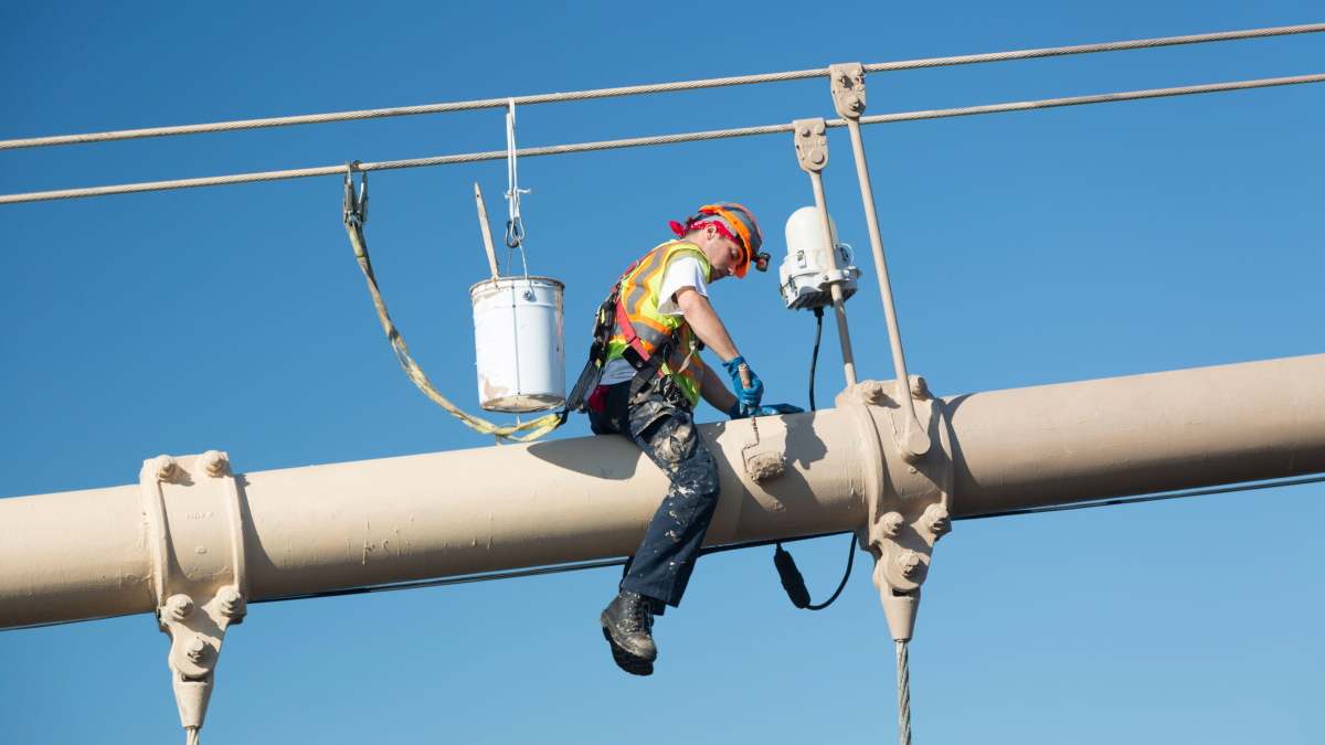 Un trabajador pintando el puente de Brooklyn, en Nueva York