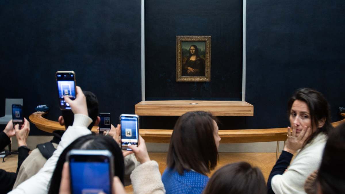 Varios visitantes fotografían con sus móviles a La Gioconda.