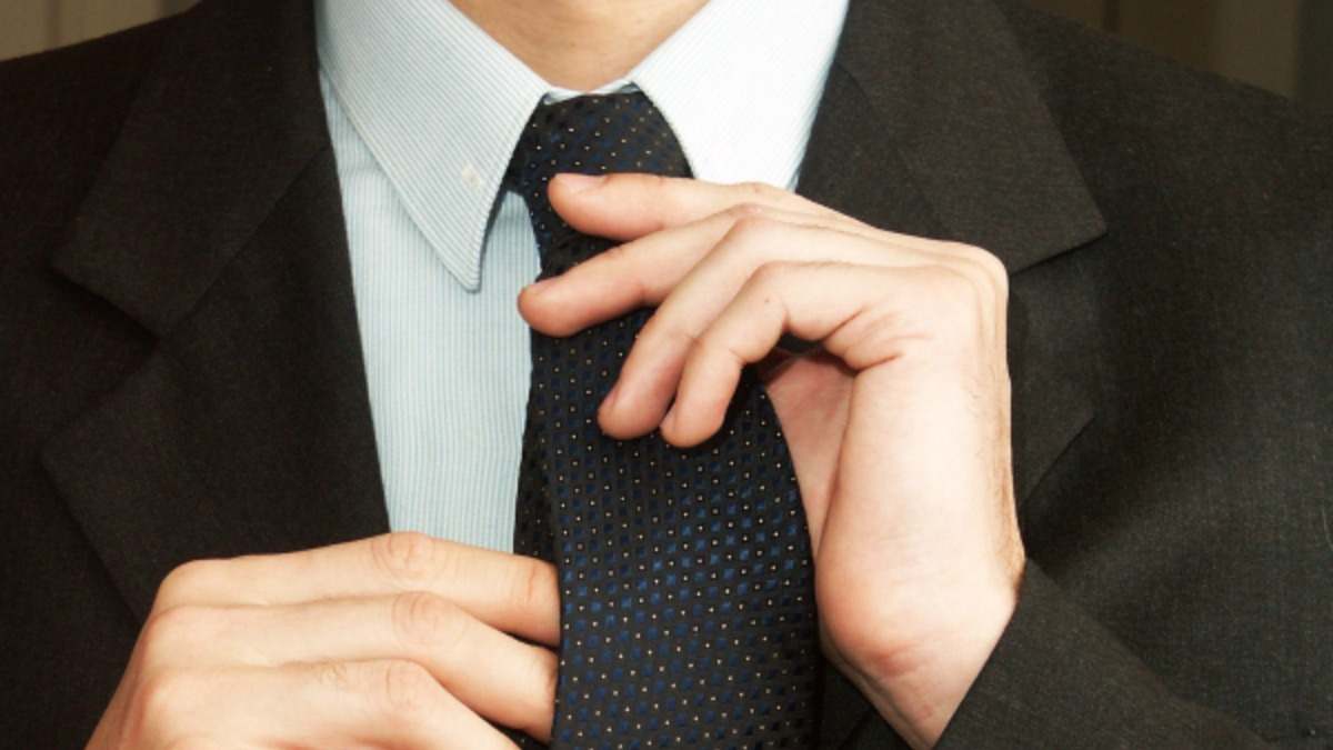 Un hombre se anuda una corbata