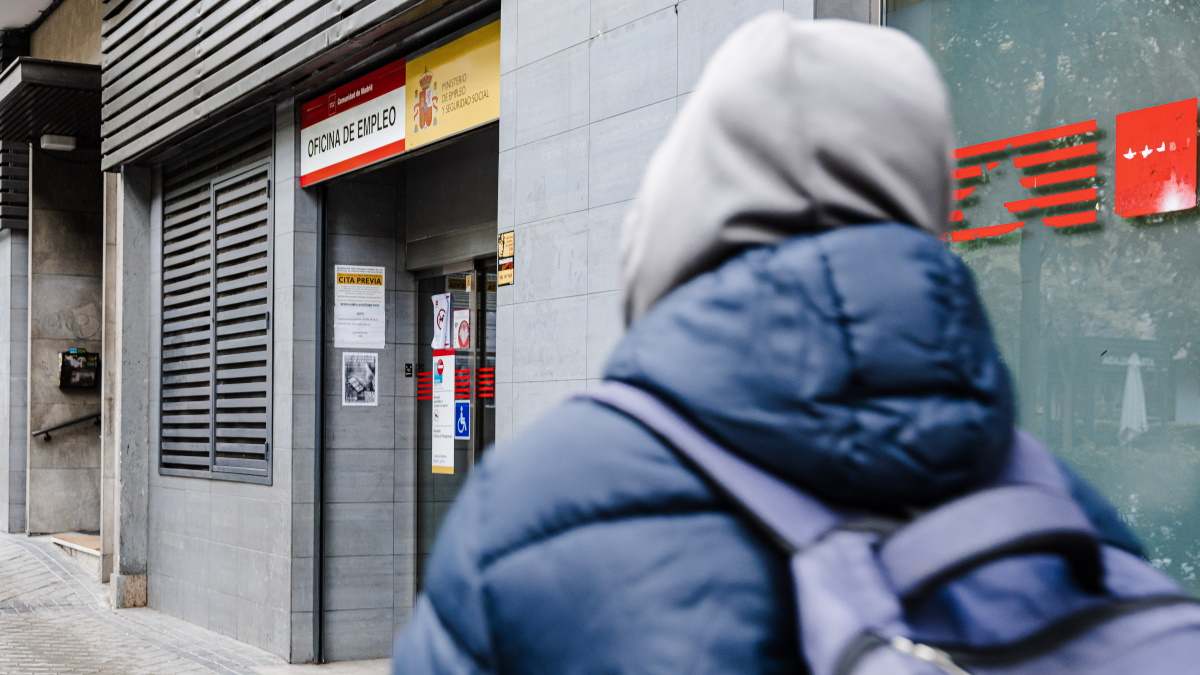 Personas encapuchada camina hacia una oficina de paro