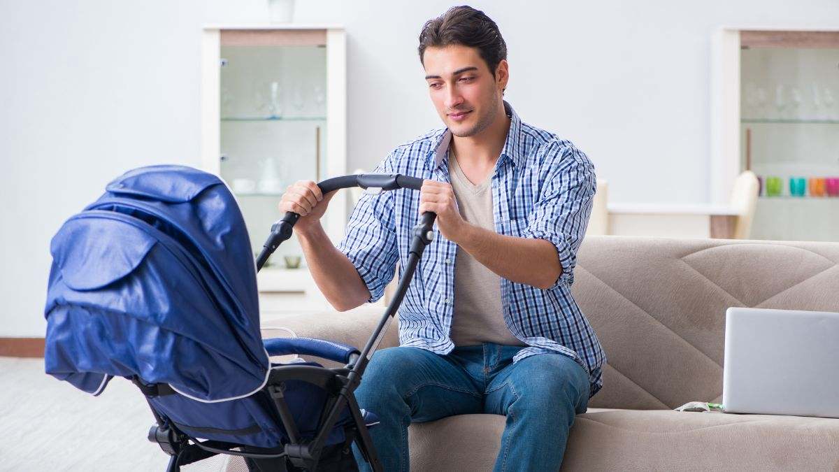 Un hombre con el carrito de su hijo en su salón.