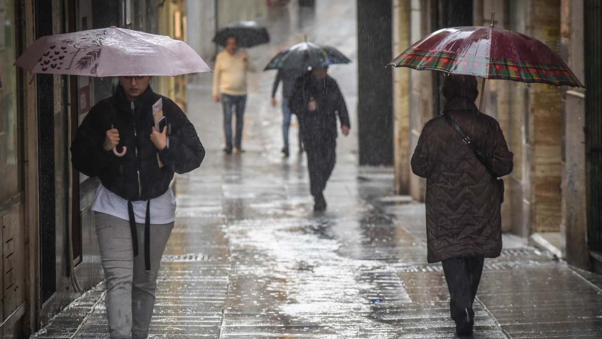 Personas cubriéndose con paraguas bajo la lluvia en Mérida.