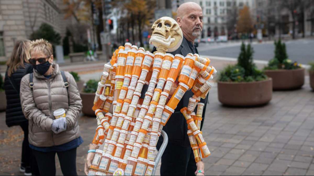 Un hombre porta un esqueleto hecho a base de botes de OxyContin en una protesta contra Purdue Pharma.