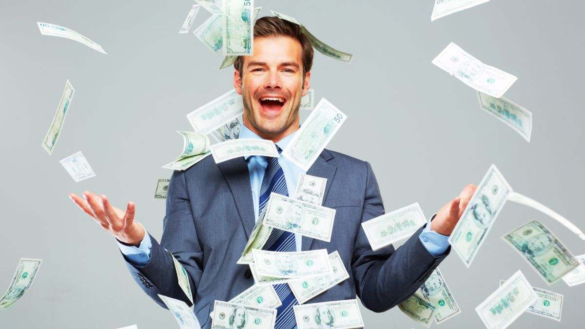 Imagen de recurso de una persona rica con billetes volando.