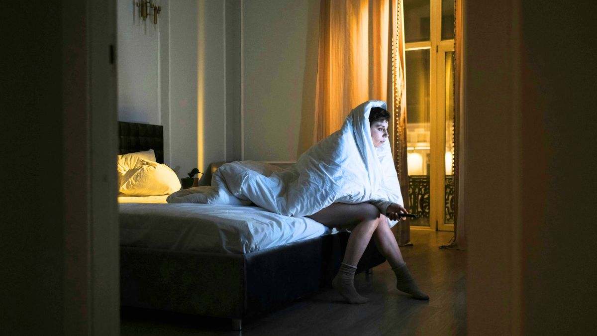 Una persona ve la televisión, a punto de irse a dormir