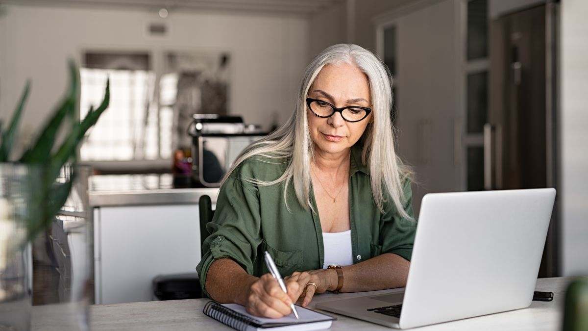 Una mujer adulta realiza una consulta ante el ordenador.