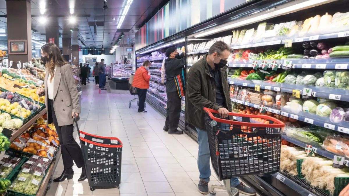 Varias personas compran en un supermercado español