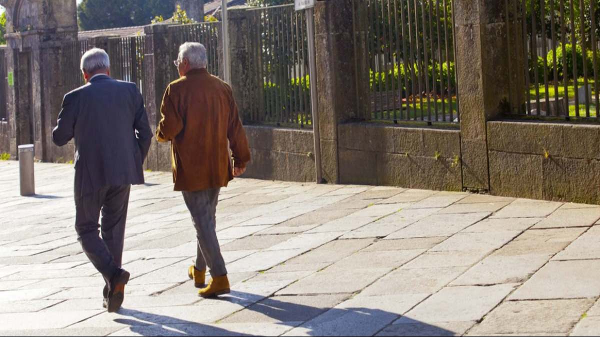 Dos hombres sénior paseando por la calle.