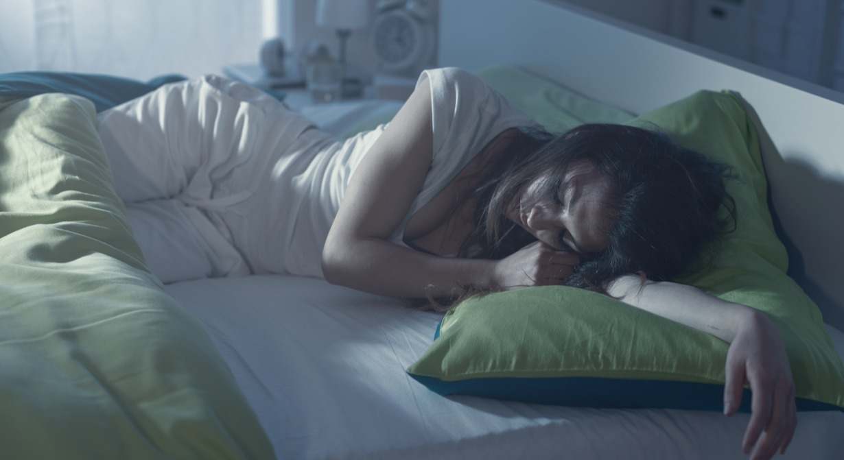 una mujer duerme en una cama