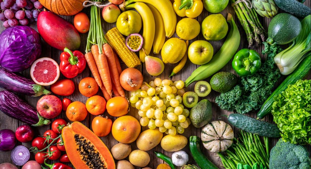 Muchas frutas y verduras ordenadas por colores como un arcoíris