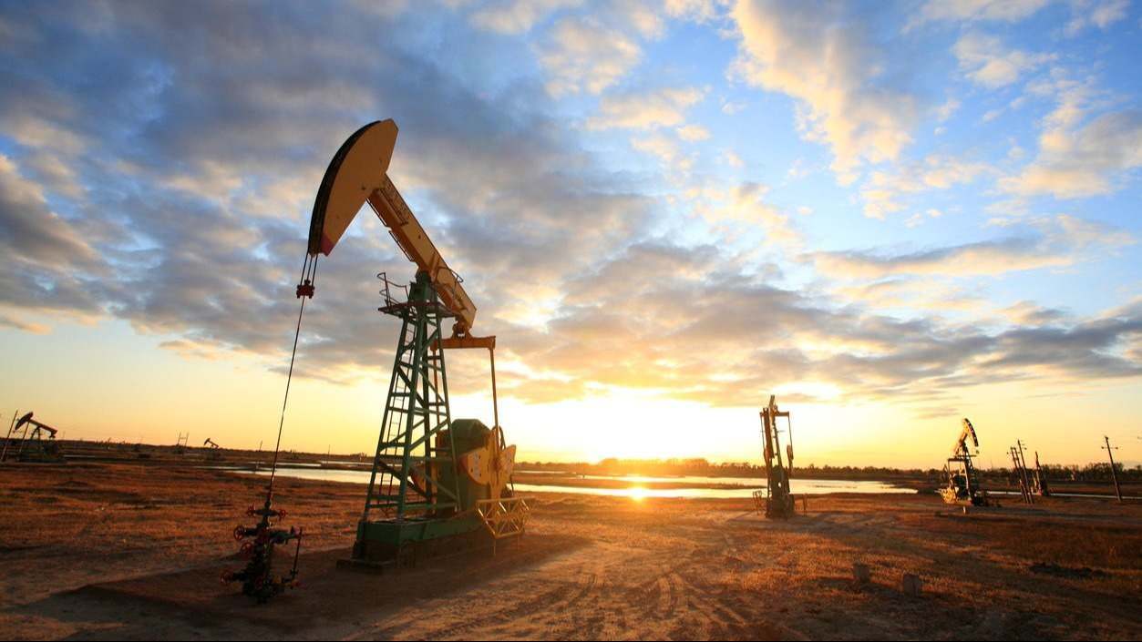 Pozos de petróleo delante de un atardecer