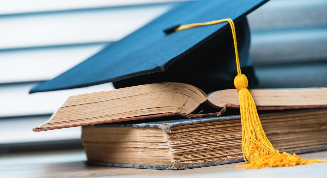 birrete de graduación y libros universitarios