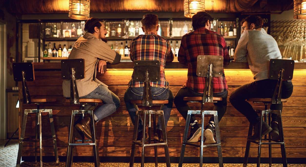 un grupo de hombres charla en un bar
