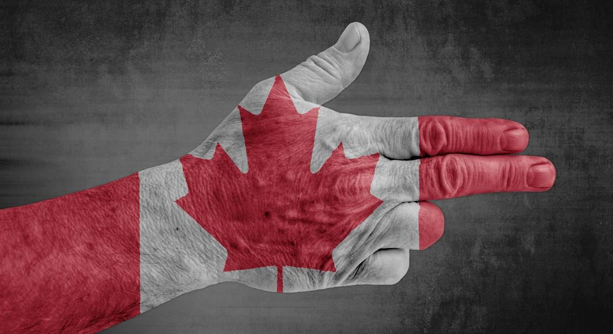 Una mano con los colores de Canadá haciendo el gesto de una pistola