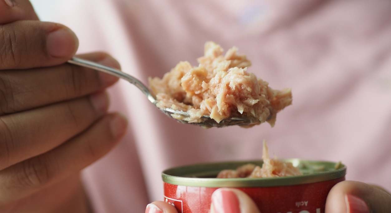 Un consumidor abre una lata de atún