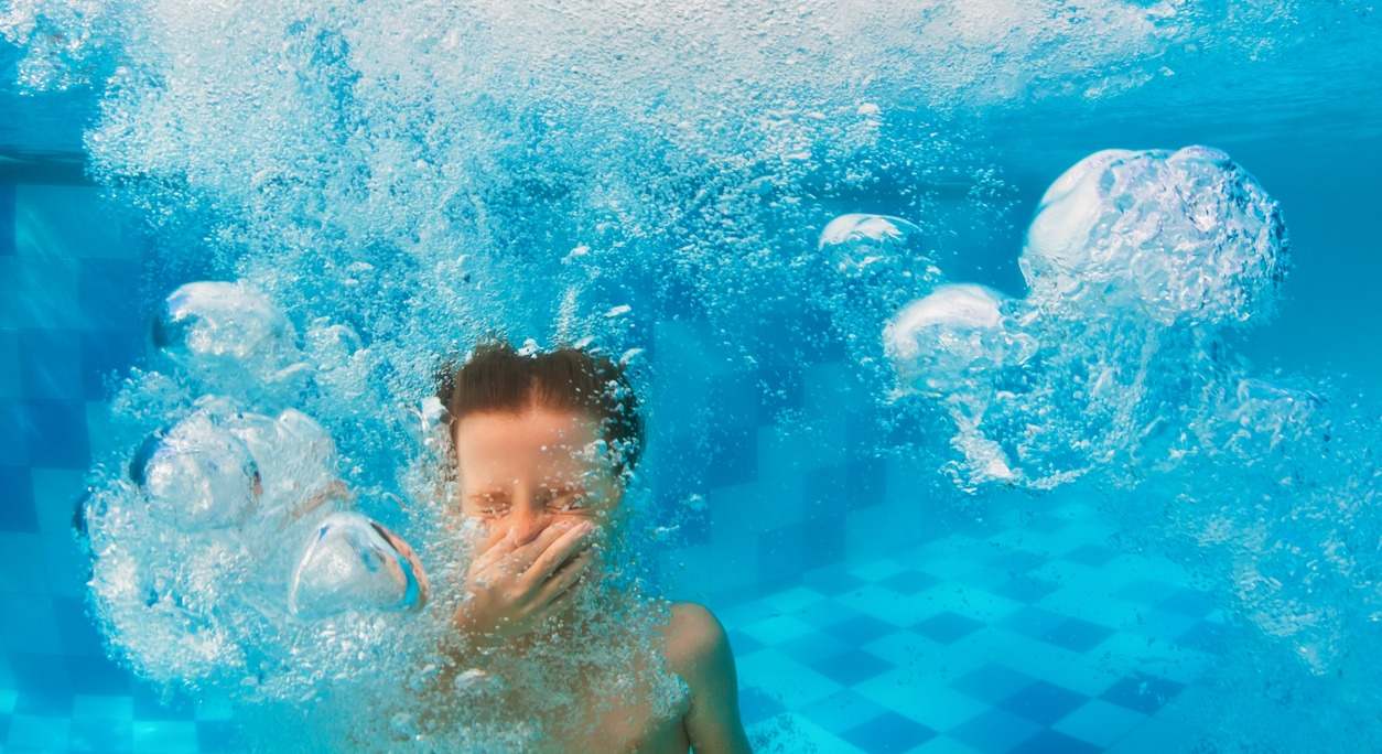 niño buceando en una piscina