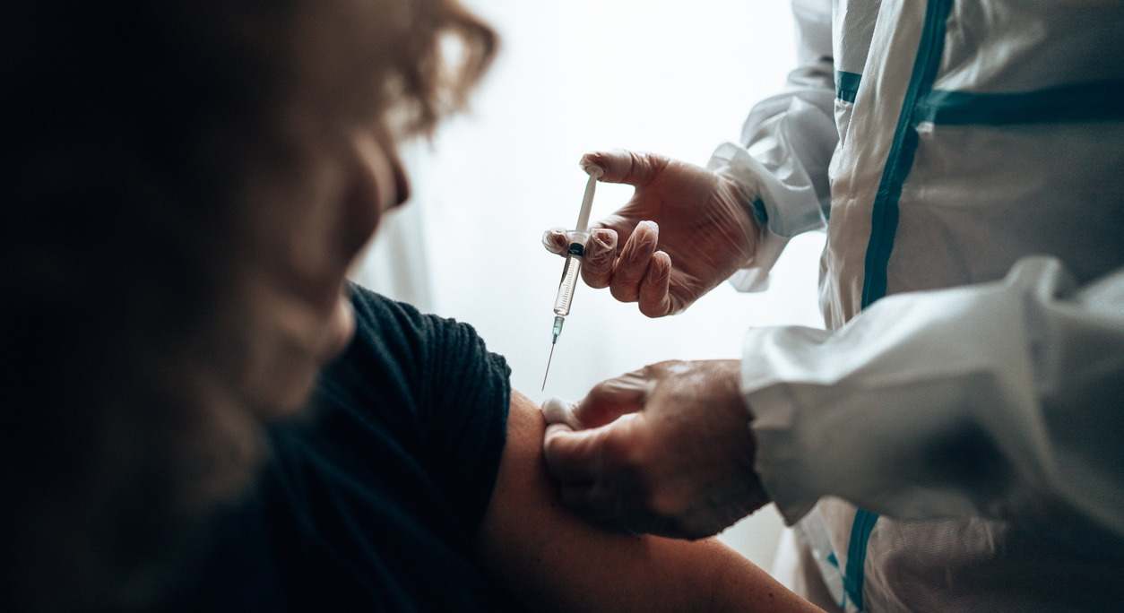 un sanitario suministra una vacuna a un paciente