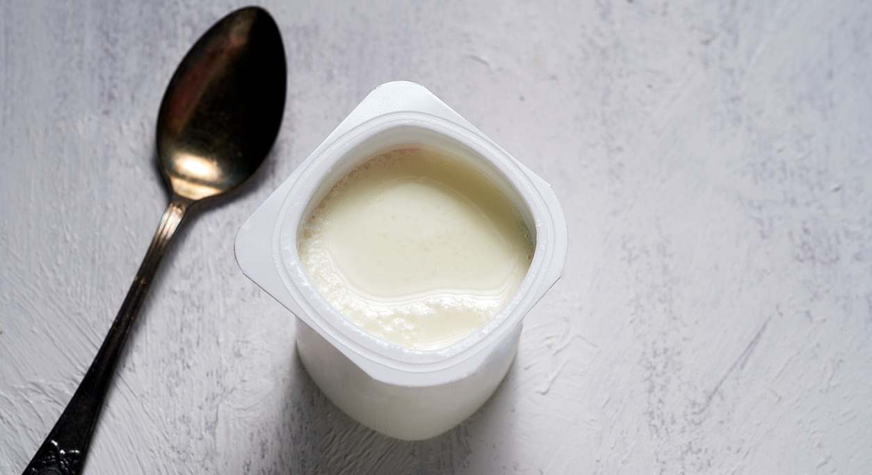 yogurt abierto junto a una cuchara
