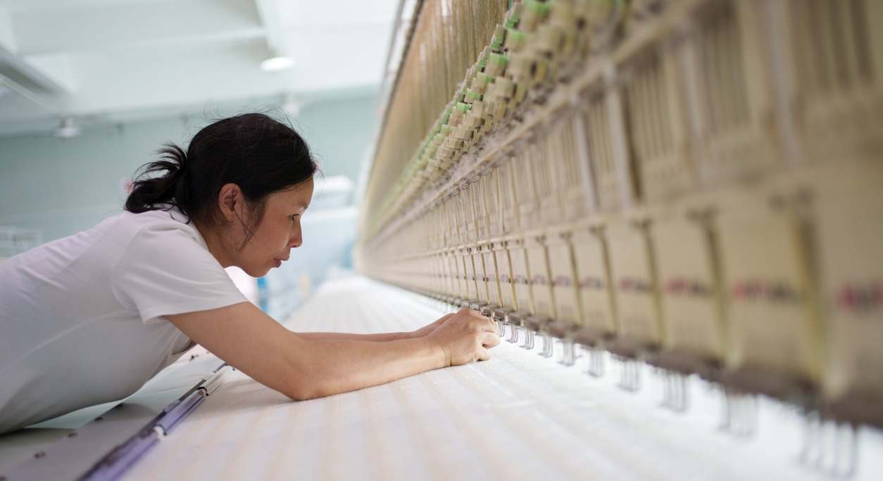 Trabajadora en el telar mecánico de una fábrica textil de China