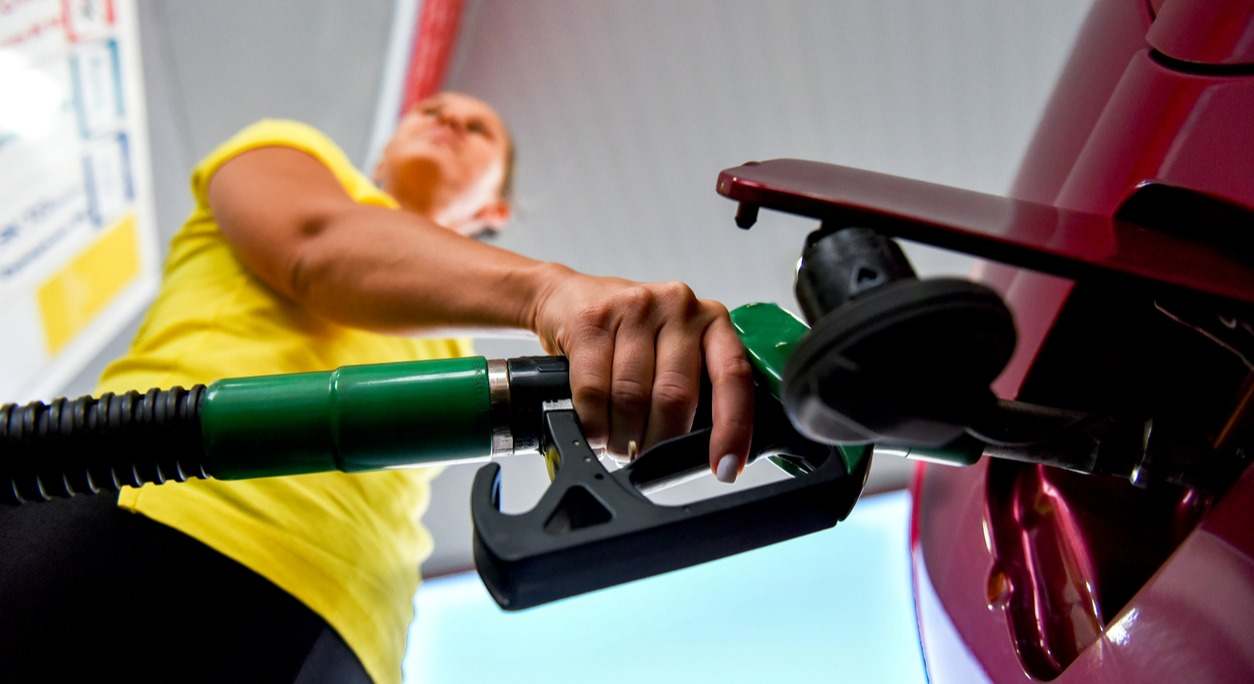 un usuario llena el depósito de combustible