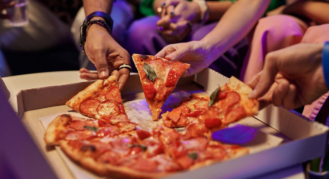 Varias personas comen pizza