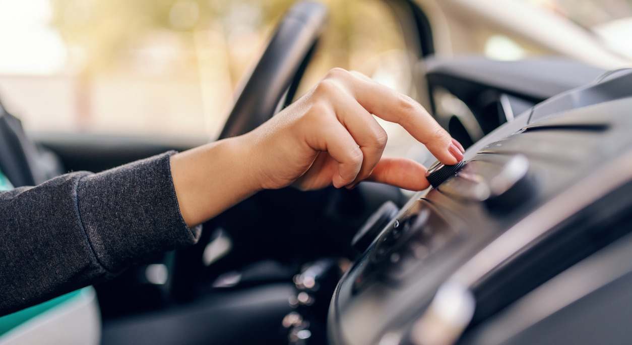 un conductor ajusta la radio de su coche