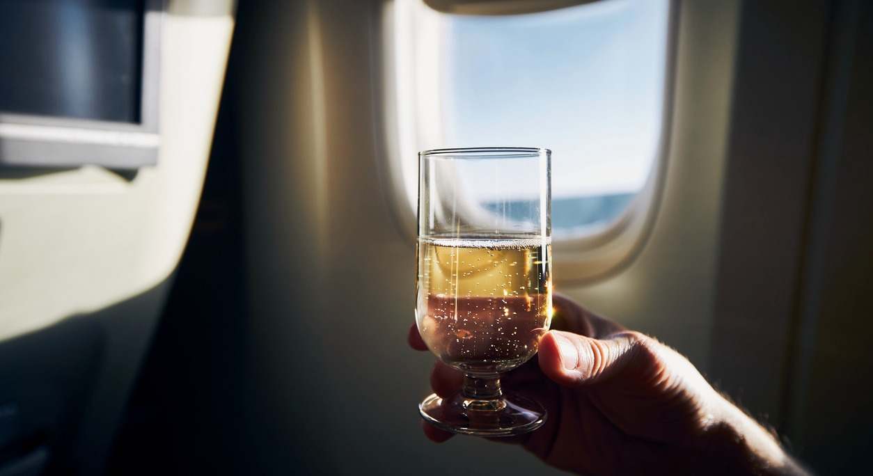 Un viajero bebe una copa de vino durante un vuelo