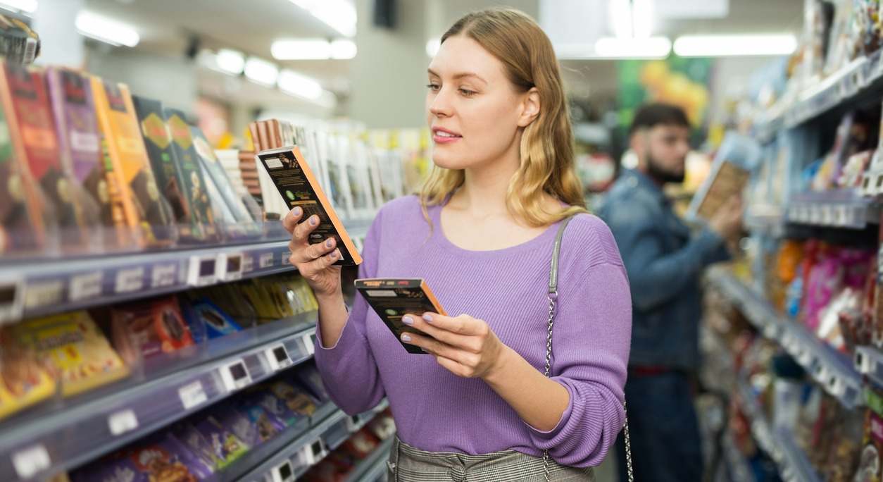 mujer compra chocolate en un supermercado